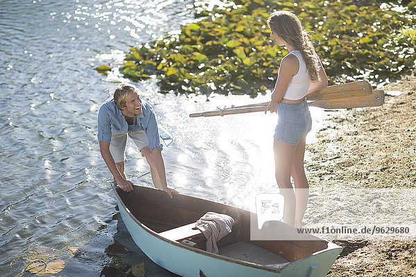 Junges Paar mit einem Ruderboot am See