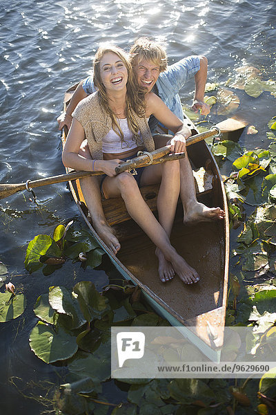 Happy young couple in a rowing boat on a lake