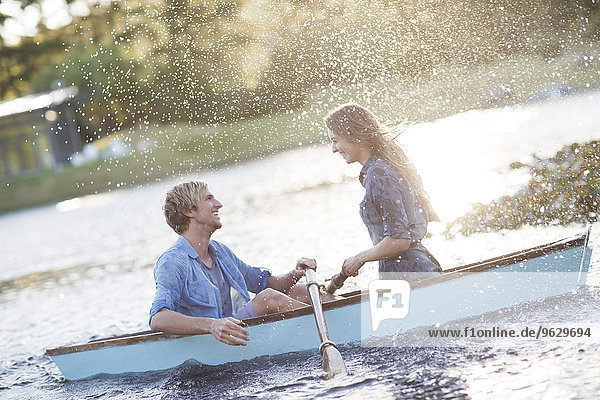 Junges Paar im Ruderboot auf einem See