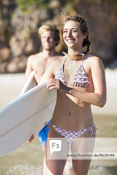 Junges Paar mit ihren Surfbrettern im Meer