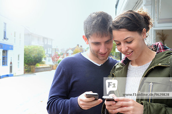 Young couple using smartphones