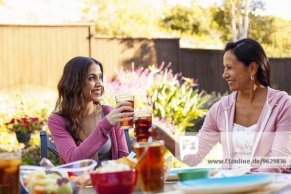 Mother and daughter toasting in garden