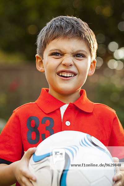 Junge mit Fußball  macht Gesichter