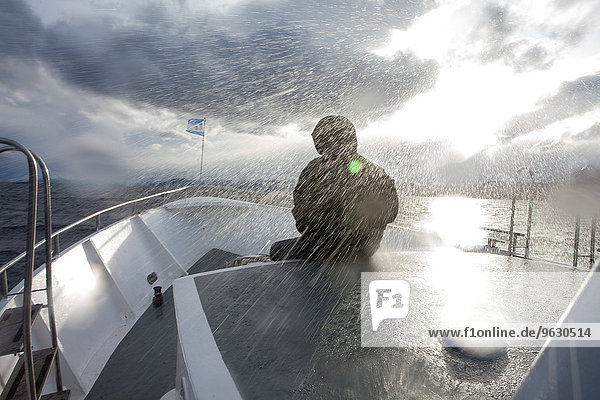 Wasserdichte Person vor dem Boot sitzend bei Regensturm  Ushuaia  Feuerland  Argentinien