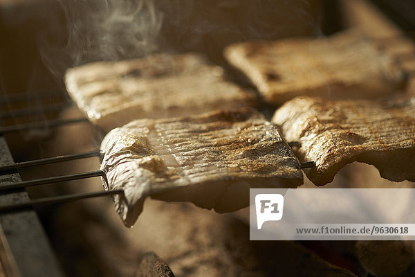 Skewered fish slices on barbeque