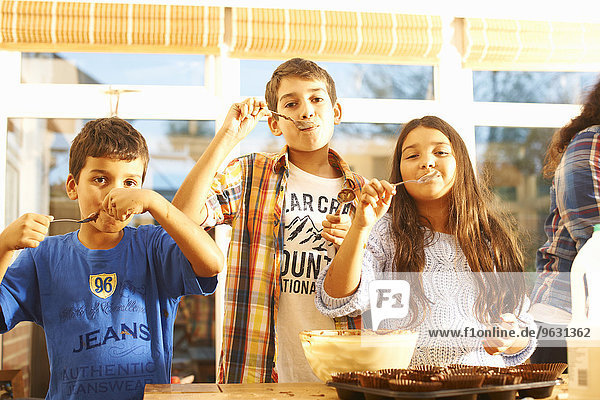 Kinder probieren Kuchenmischung in der Küche