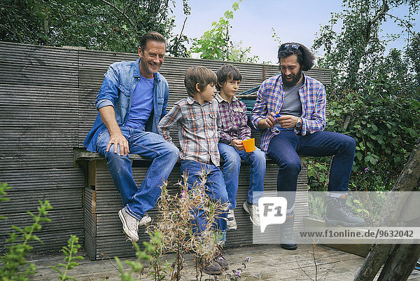 Male friends and sons taking a break on allotment