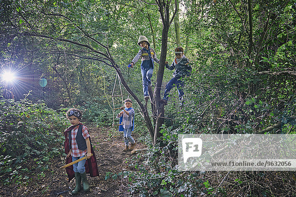 Vier Jungen verkleidet und in Waldbäumen spielend