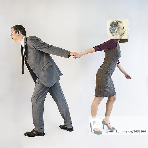 Businessman pulling businesswoman wearing mask