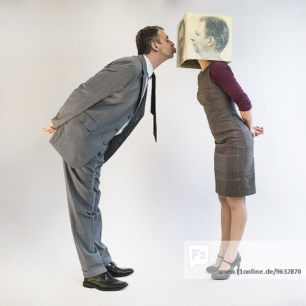 Businessman kissing businesswoman wearing mask