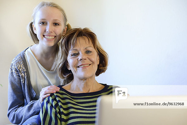 Grandmother and granddaughter with laptop  smiling  portrait