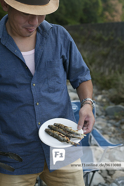 Fisch Pisces Mann Picknick halten Teller gegrillt