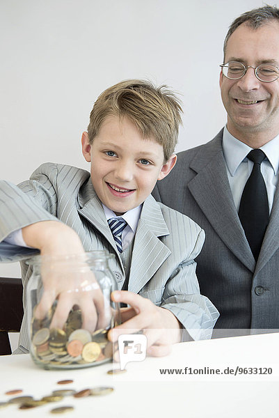 Father and son with piggy bank  smiling