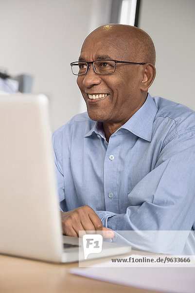 Smiling businessman desk computer African