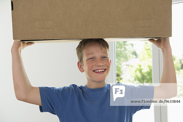 Young boy carrying box new apartment