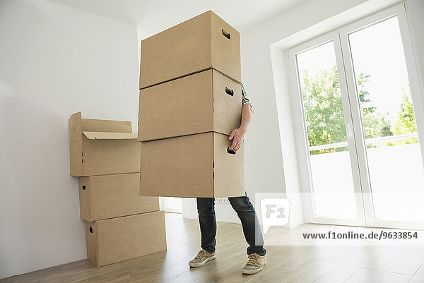 Man carrying heavy boxes moving in new home