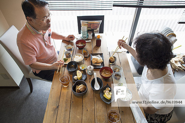 sitzend Frau Mann Eßstäbchen Lebensmittel essen essend isst Tisch japanisch
