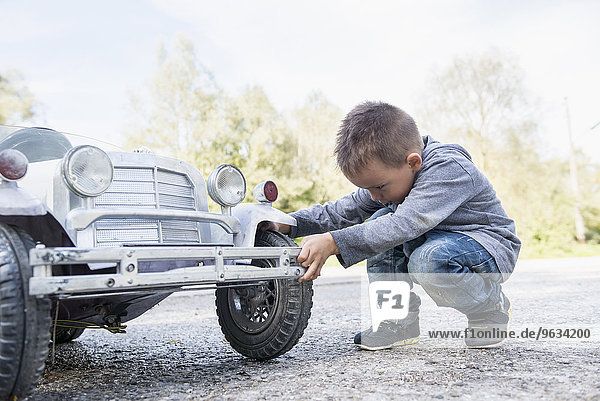 Boy child controlling wheel model toy vintage car