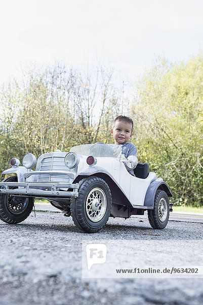 Young kid boy driving model vintage car
