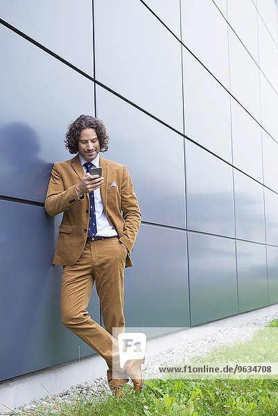 Portrait man business suit cell phone reading SMS