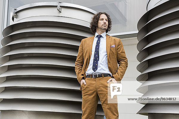Businessman standing in front of ventilation shaft