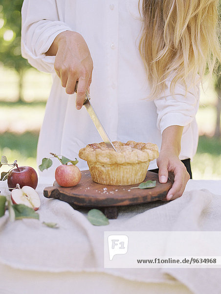 stehend Frau Lebensmittel schneiden Obstgarten Apfel Tisch