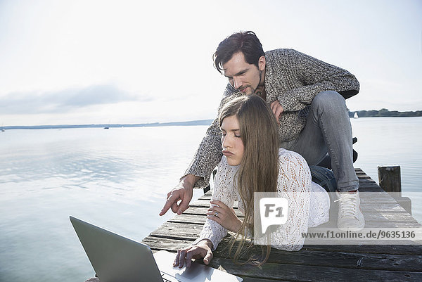 couple together lake outdoors working computer