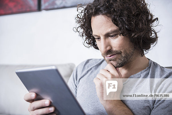 Man using a digital tablet at home