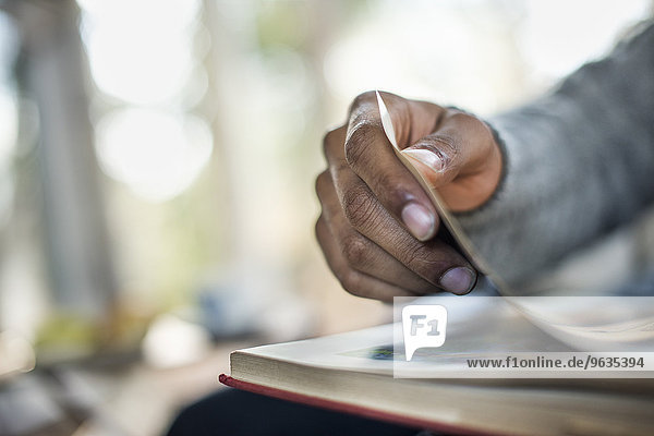 Close up of a man's hand flipping through the pages of a book.