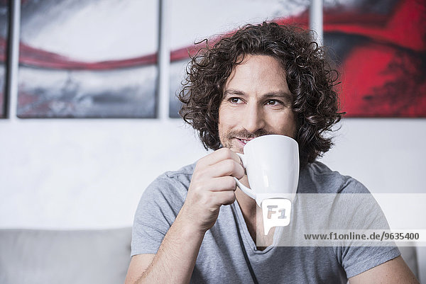 Man drinking cup of coffee at home