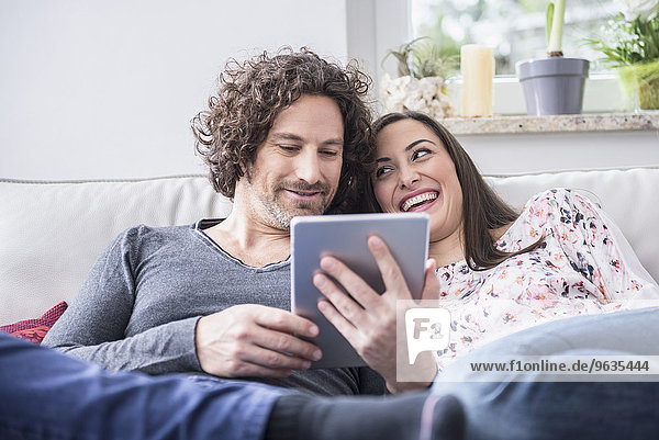 Happy couple using digital tablet