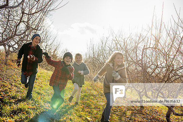 Four children running outdoors in winter