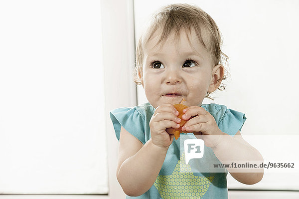 Baby girl eating fruit portrait happy smiling
