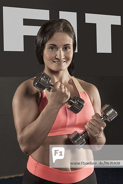 Portrait muscular woman weight training barbells