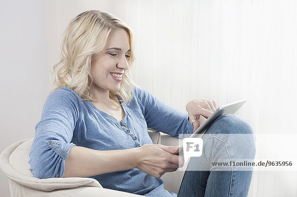 Blond young woman chair tablet computer sitting