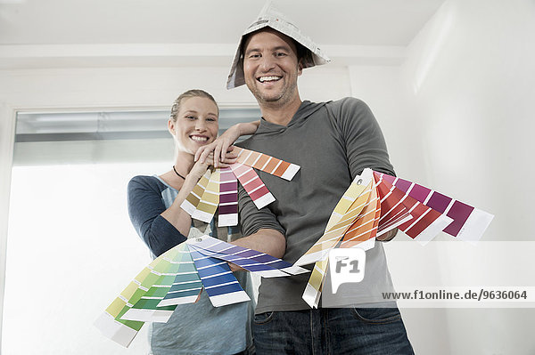 Couple choosing colour samples and smiling