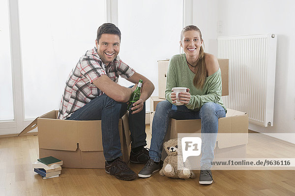 Couple taking a break from unpacking in their new home