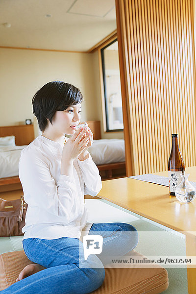 Young Japanese woman drinking sake
