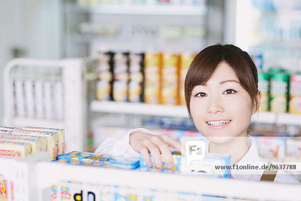 Young Japanese woman working at convenience store