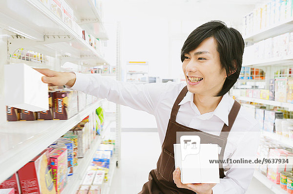 Young Japanese man working at convenience store