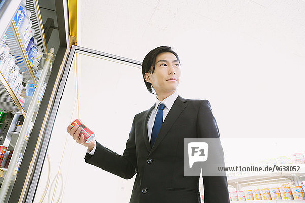 Young Japanese businessman in a convenience store