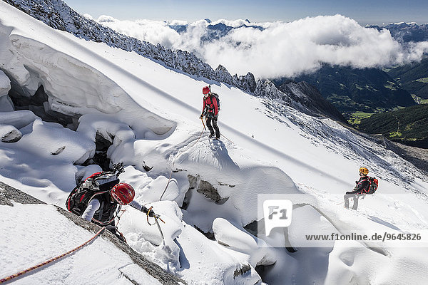 Mountaineers ascending Mt Löffler via Trippachkees  snow divide  rope team at the marginal crevasse of Trippachscharte  Ahrntal Valley  Tauferer Ahrntal Valley and Puster Valley below  South Tyrol  Italy  Europe