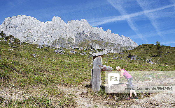 Wanderin erfrischt sich bei einem Brunnen  Almlandschaft  Hochkönig  Mühlbach am Hochkönig  Land Salzburg  Österreich  Europa