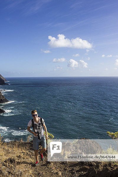 Hiker on a trail above the sea  cliffs  La Palma  Canary Islands  Spain  Europe