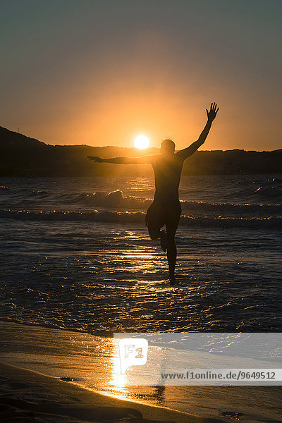 Young man  silhouette  jumping on the beach at sunset  sunset by the sea  Haute-Corse  Corsica  France  Europe