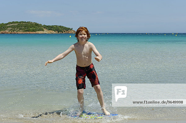 Boy surfing with his boogie board  beach board or skimboard on the beach  bay of Rondinara  southeast coast  Corsica  France  Europe