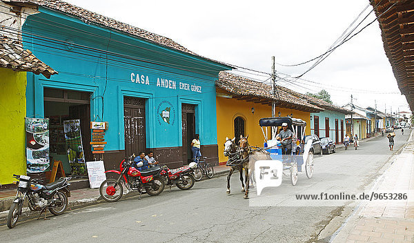 Bunte Häuser an einer Straße  Pferdekutsche fährt vorbei  Granada  Provinz Granada  Nicaragua  Nordamerika