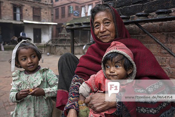 Ältere Nepalesin mit zwei Kindern  Bhaktapur  Nepal  Asien