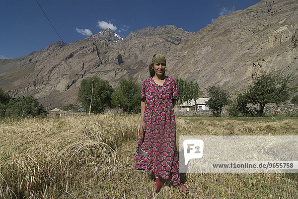 Bäuerin im Feld  dahinter Berge  Bartangtal  Tadschikistan  Zentralasien  Asien