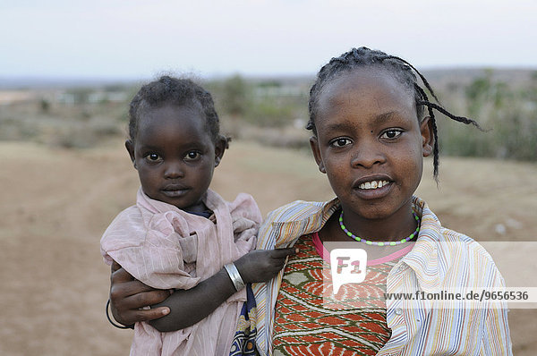 Junges muslimisches Mädchen trägt ein kleines Kind Yabello Südäthiopien Äthiopien Afrika